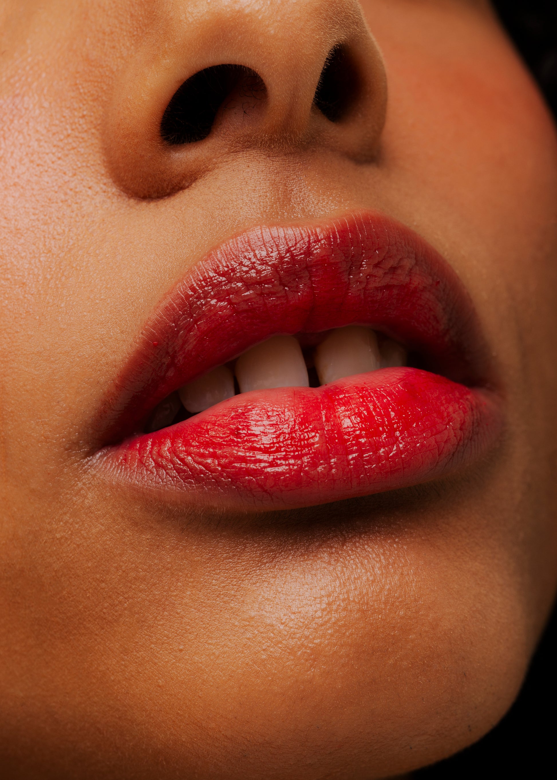 Foto super aproximada de lábios maquiados com batom líquido lip tint na cor laranja aplicado